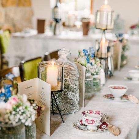 Hochzeitstafel mit Bumendekoration, Kerzen und Platzkarten